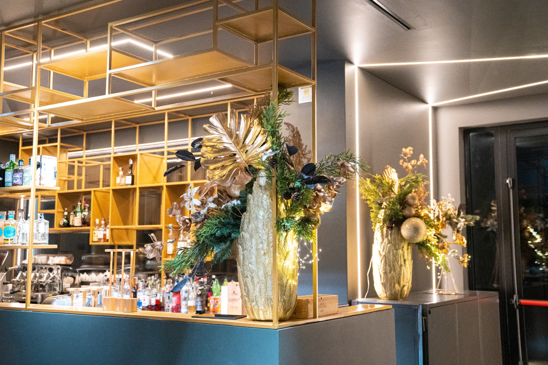 Bancone bar del Ristorante Emporio a Rondissone con dettagli dorati e composizioni floreali