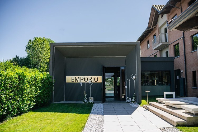 Ingresso esterno del Ristorante Emporio a Rondissone con insegna dorata e giardino