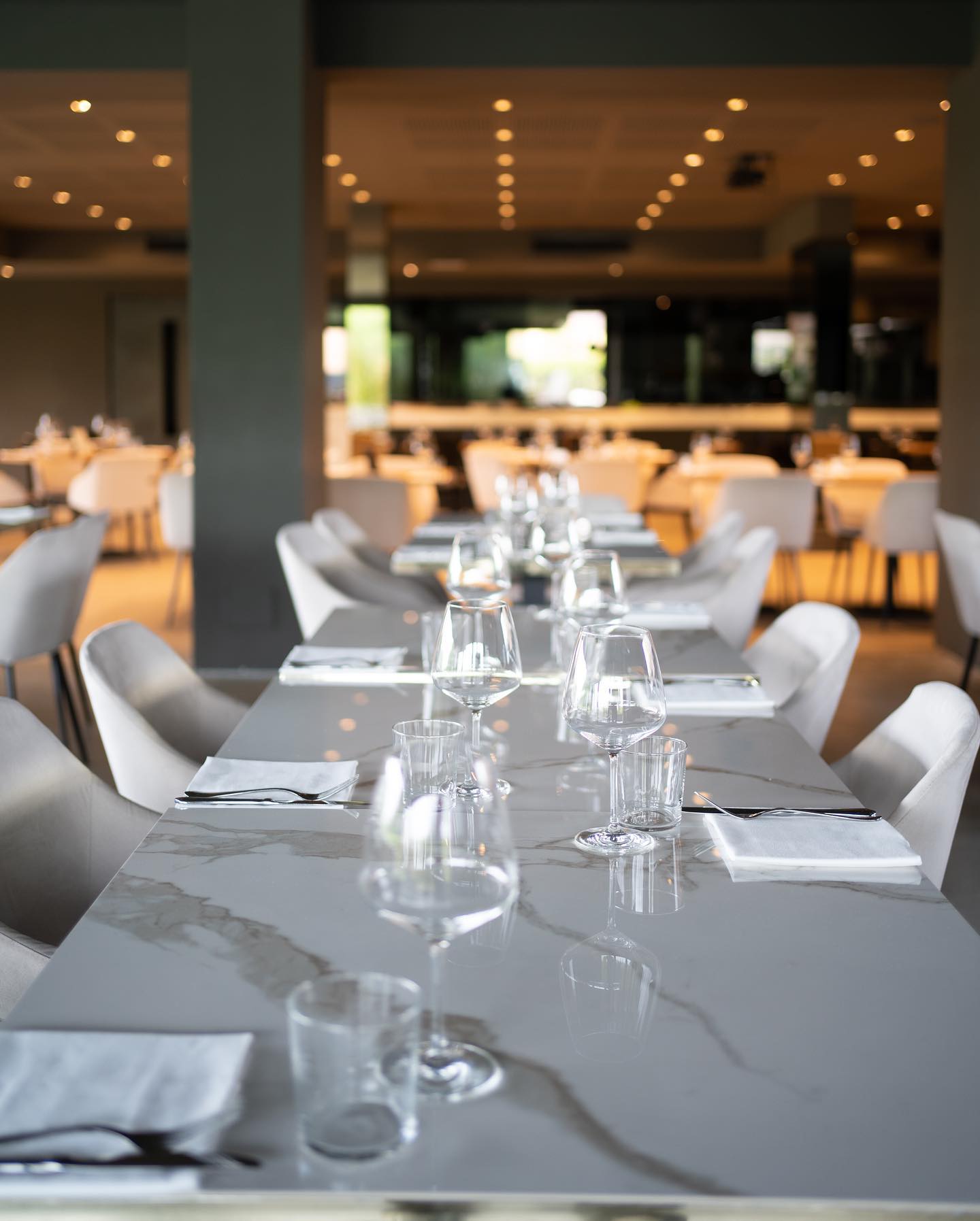 Tavolo in marmo apparecchiato nella sala moderna del Ristorante Emporio a Rondissone